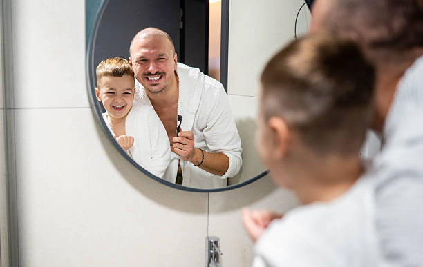 istock Dad and son brushing teeth in the bathroom 2245841714