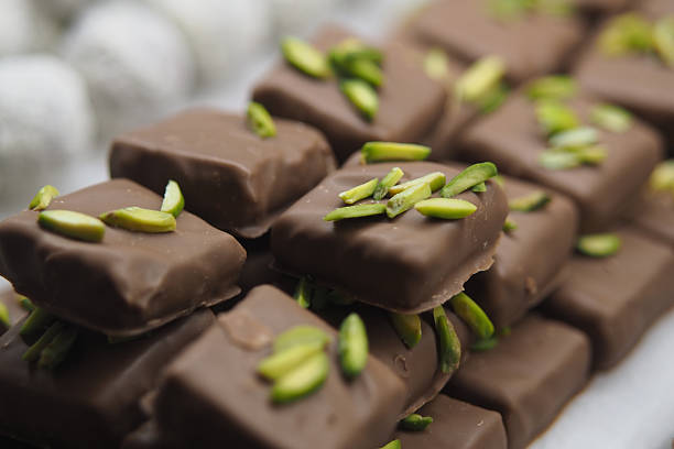 istock Chocolate confections topped with green nuts on display 2245843261