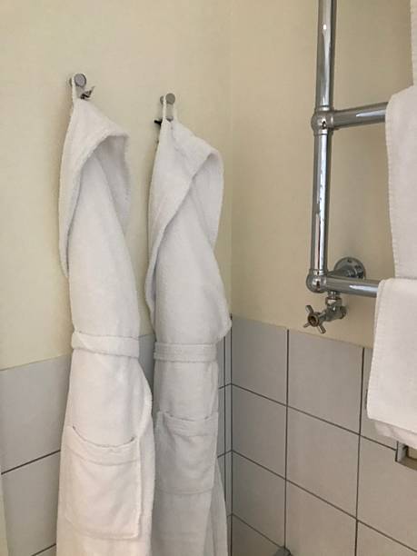istock White Bathrobes Hanging in Minimalist Hotel Bathroom 2245843374