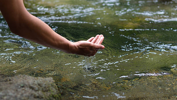 istock Calm Hand Collecting Fresh Water From Clear Stream In Nature For Refreshment 2245848427