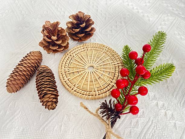 istock Natural Elements for Festive Decoration with Pinecones, Traditional Woven Plate, Red Berries, and Greenery on White Background for Holiday Themes 2245851106