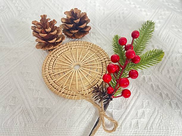 istock Decorative Holiday Arrangement with Pine Cones, Festive Red Berries, and Greenery on a Textured White Background 2245851112