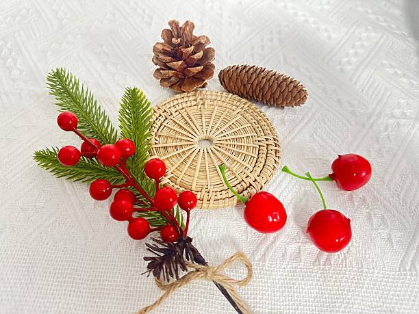 istock Decorative Christmas Elements with Berries, Pine Cones, and Woven Mat on White Background for Festive Holiday Aesthetics 2245851153