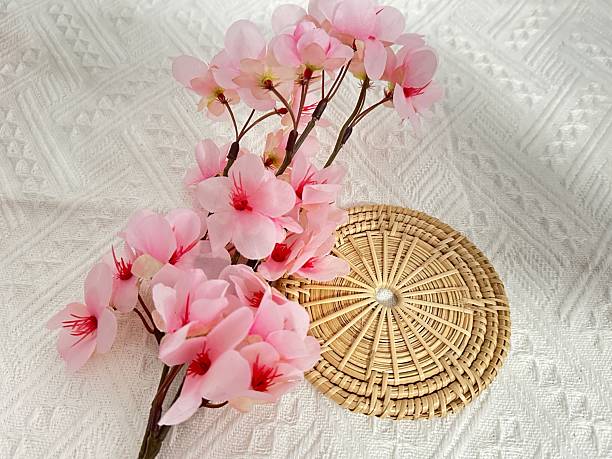 istock Delicate Pink Cherry Blossom Arrangement on Woven Mat with Elegant Texture and Layered Design for Spring and Summer Decor 2245851311