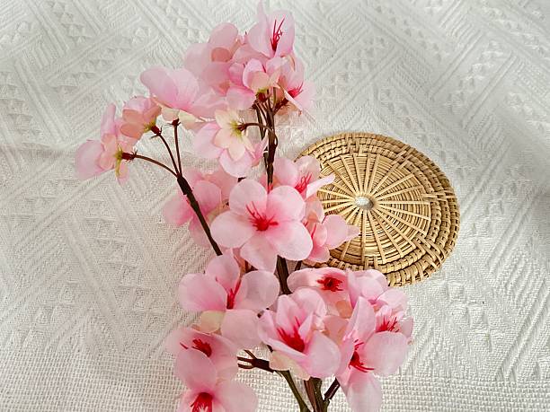 istock Delicate pink flowers arranged elegantly on a textured white background with a woven mat, showcasing nature's beauty and serene aesthetics in home decor 2245851317