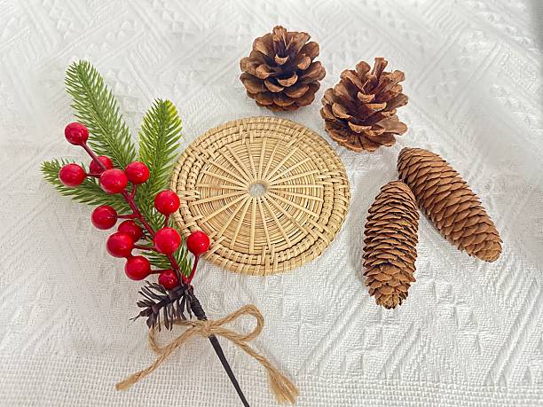 istock Festive Arrangement of Pinecones, Red Berries, and Natural Elements on Textured White Surface for Holiday Decorations and Seasonal Aesthetic 2245852007