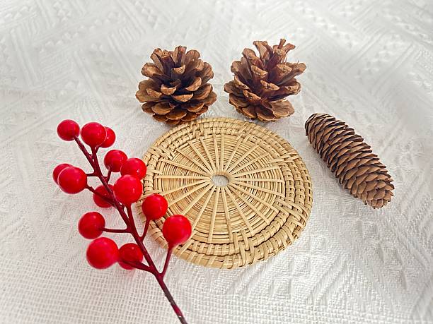 istock Natural Elements Decoration with Pine Cones, Red Berried Sprig, and Woven Mat on White Background for Cozy Aesthetic and Rustic Inspiration 2245852185