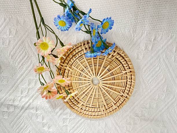 istock Elegant woven basket adorned with colorful spring flowers on a textured white surface, perfect for home decor or floral arrangement inspiration 2245852431