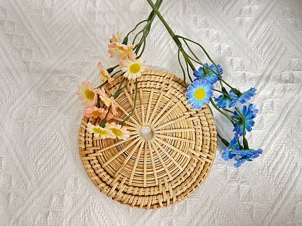 istock Circular woven basket with colorful artificial flowers placed on a textured white background, perfect for home decor or floral arrangements 2245852473