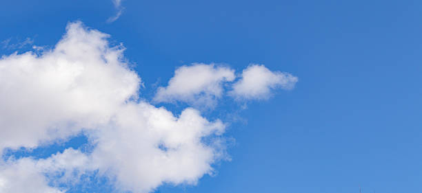 istock Bright blue sky with fluffy white clouds. Natural background with soft cloud shapes illuminated by sunlight. Perfect for weather, nature, and landscape themes. 2245856285