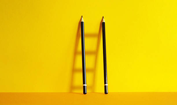 istock Pencils forming a metaphorical ladder symbolizing career progress on bright yellow background. Creativity, vision and growth 2245857944