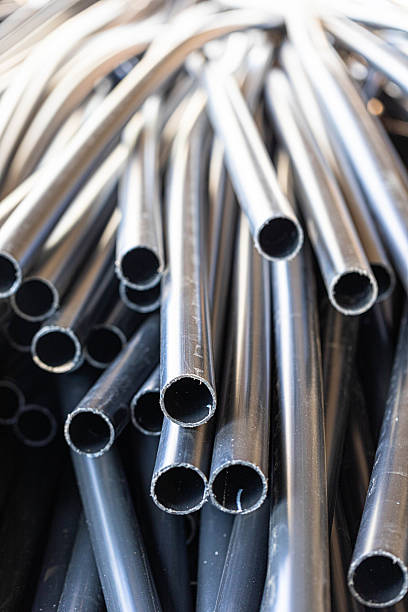 istock Black plastic pipes stacked together in a chaotic arrangement 2245859273