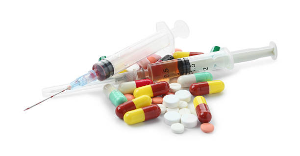 istock Drug addiction. Different pills and syringes isolated on white 2245861930
