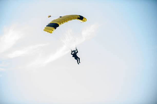 Two parachutes of paragliders with cloudy sky background