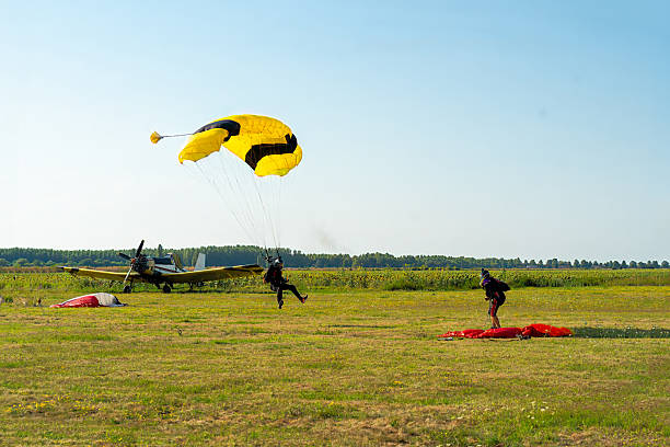 istock Skydiving duo: instructor and student tandem jump preparing for a precise landing on an open field 2245866956