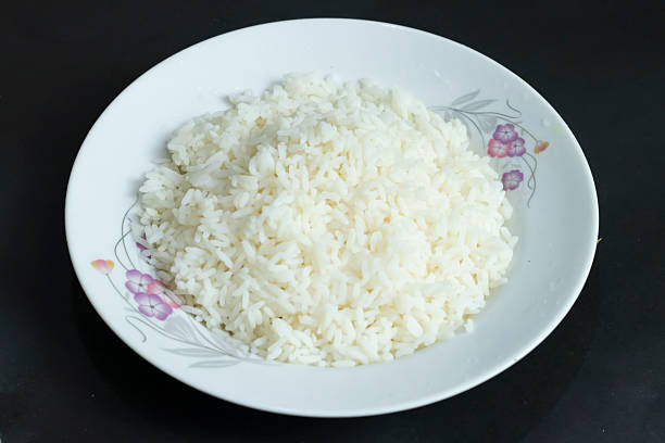 cooked fluffy white rice served in a decorative floral plate, a staple food for healthy meals