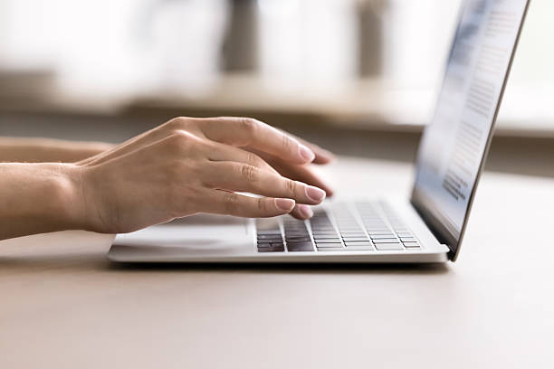 istock Cropped close up female hands typing on notebook on table 2245869104