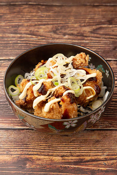 Rice bowl topped with fried chicken dressed in Worcester sauce, mayonnaise and spring onions