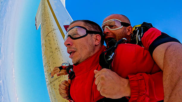 istock Tandem skydiving selfie during freefall with instructor and passenger, wrist camera view 2245872284