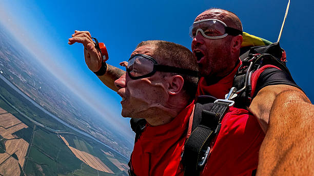 istock Tandem skydivers selfie during freefall with action camera in wide blue sky 2245872302