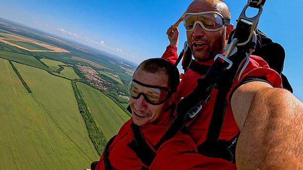 istock Two skydivers take a selfie during tandem jump from a plane, capturing adrenaline and wide landscape view 2245872307