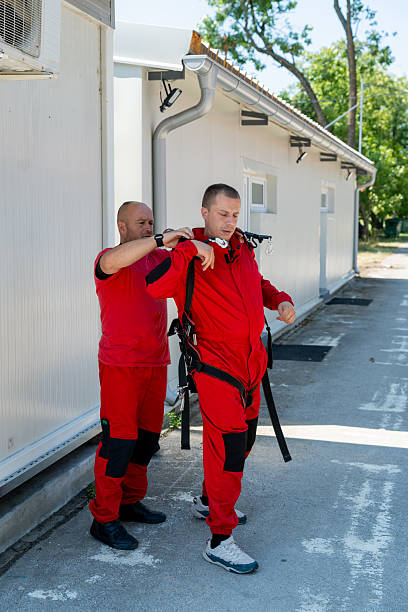 istock Instructor helps student secure parachute harness during skydiving prep and safety check 2245873979