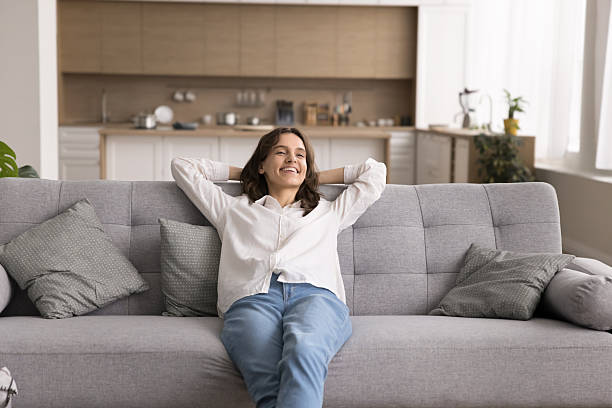 istock Happy young woman reclining on couch at stylish studio flat 2245875205
