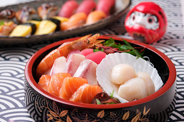 Fresh Sashimi and Sushi Bowl with Salmon Tuna and Scallops on Table