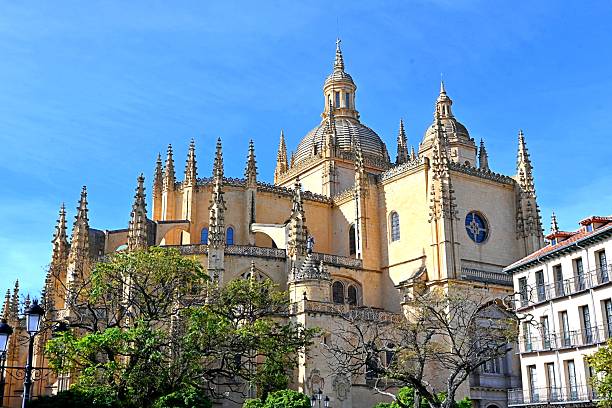 A photo of Plaza Mayor in Segovia, Spain, with an impressive view of the Cathedral of Santa Maria. The shot shows the lively historic square surrounded by traditional buildings and cafes, with the majestic cathedral rising above them with its characteristic Gothic architecture.