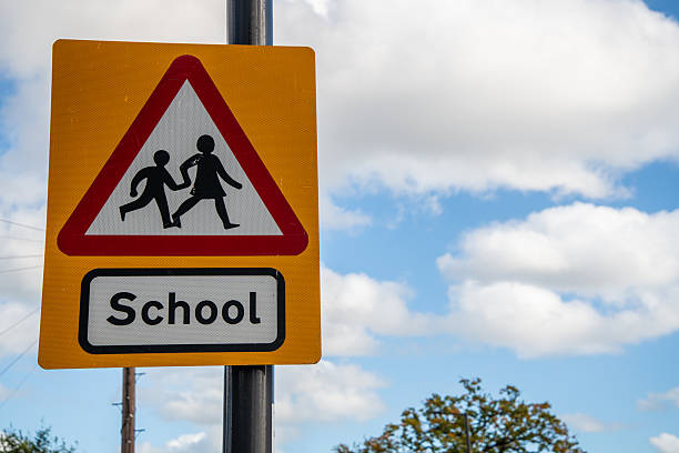 istock Triangle School Warning Sign on Yellow Background by the Road 2245885612