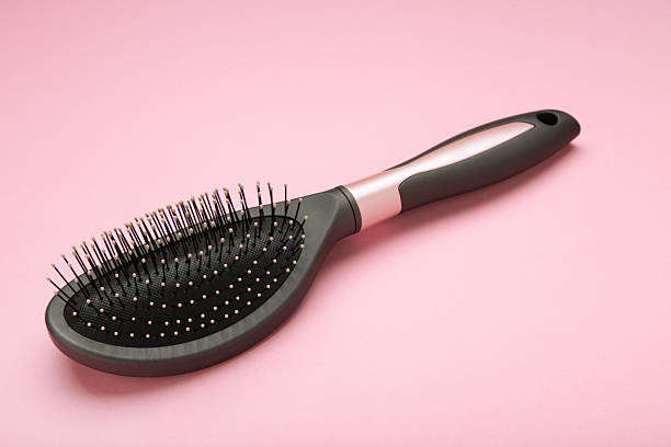 Massage hairbrush on pink background. Space for text. Top view
