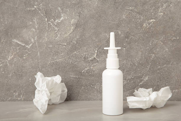 Nasal drops medicine bottle on grey background. Top view