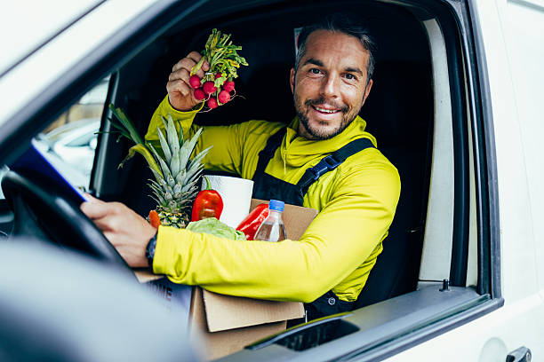 istock Smiling delivery man holding radishes with groceries inside van 2245888541