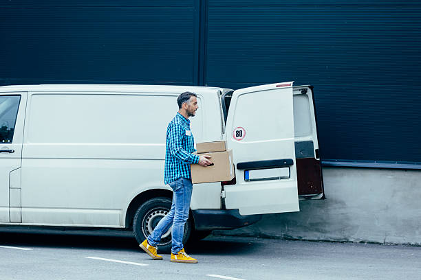 istock Delivery man carrying packages from white van 2245888596