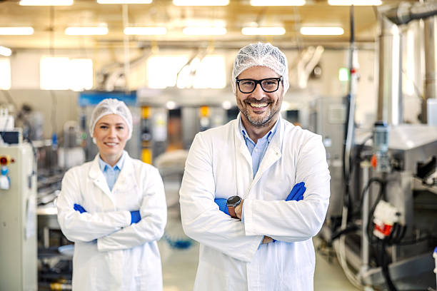 istock Food processing engineers smiling in modern factory 2245890747