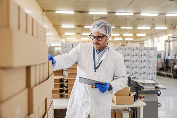 istock Man quality controlling product boxes in factory warehouse 2245890815