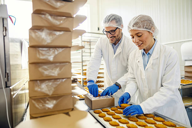 istock Food factory workers packaging fresh made cookies 2245891079