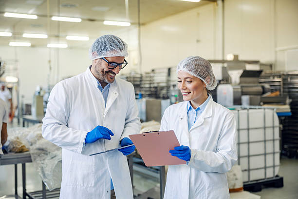 istock Food factory workers discussing quality control report 2245891117