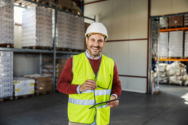 istock Warehouse manager smiling holding tablet in safety vest 2245892284