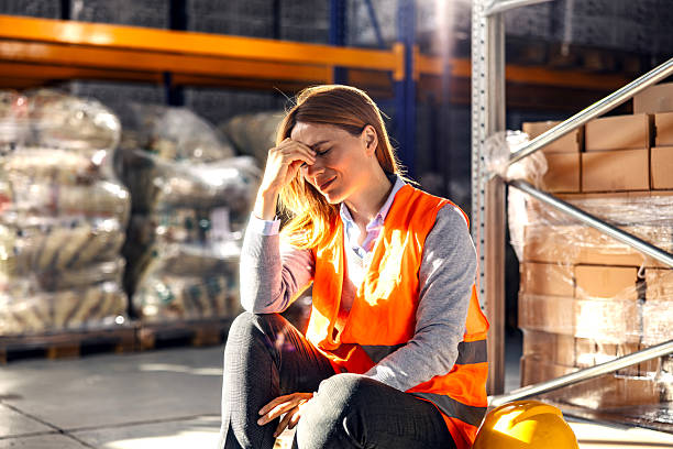 istock Stressed woman worker experiencing headache in warehouse 2245892444