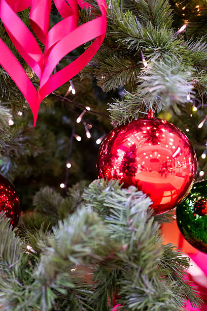 istock Green Pine Branches with Red Ribbon and Ornaments 2245894542