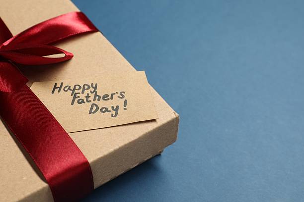 istock Card with phrase Happy Father's Day and gift box on blue background, closeup. Space for text 2245902102