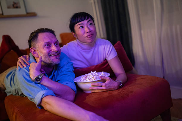 istock Diverse couple eating popcorn and watching movie 2245903092