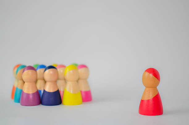 istock Red wooden figure standing out from a crowd 2245907458