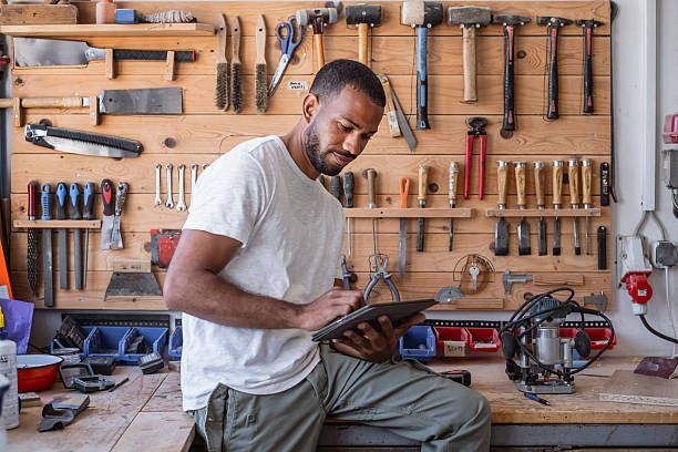 istock Mid Adult Multiracial Carpenter Working in Workshop with Hand Tools and Tablet 2245907719