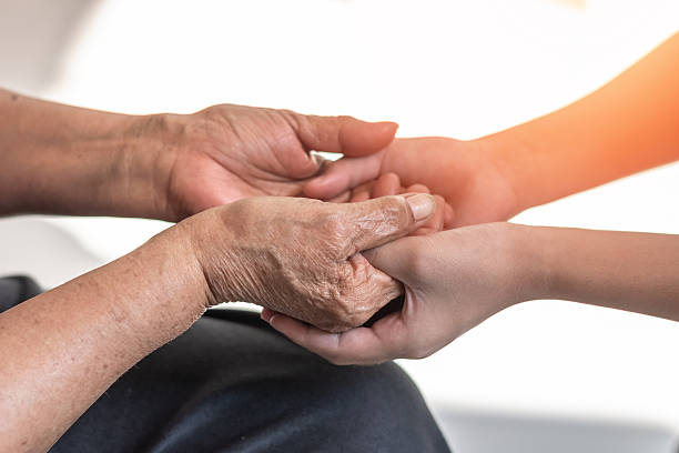 istock Parkinson disease patient, Alzheimer elderly senior, Arthritis person's hand in support of nursing family caregiver care for disability awareness day, National care givers month, aging society concept 2245908007