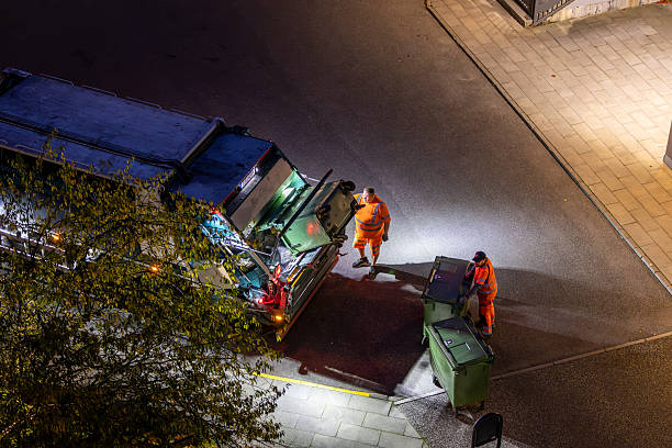 Stockholm, Sweden Oct 14, 2025 A garbage truck and men collect garbage in a residential complex.
