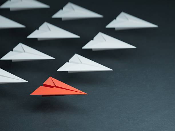istock Leaderplane concept. Red leader paper plane leading among white on black background. copy space.3D rendering on black background. 2245915249