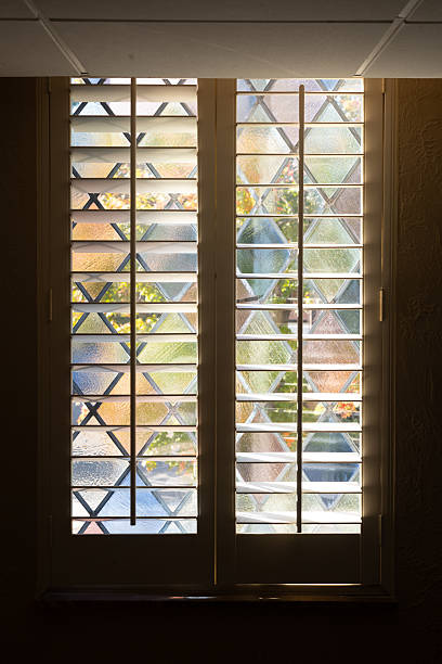 istock Warm Autumn Colors Through Stained Glass Window with Blinds 2245915716