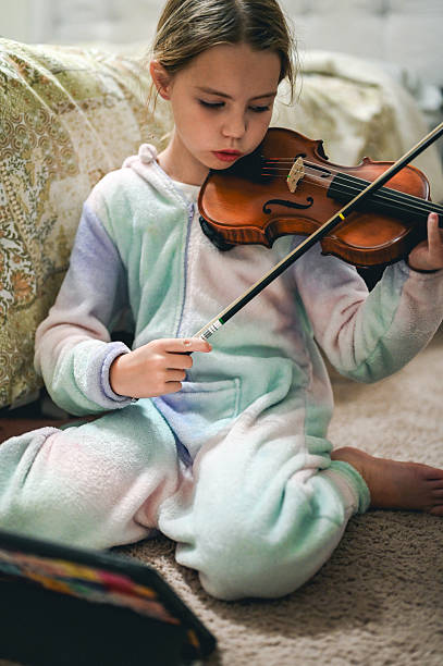 istock Young girl practicing violin at home learning music 2245917156